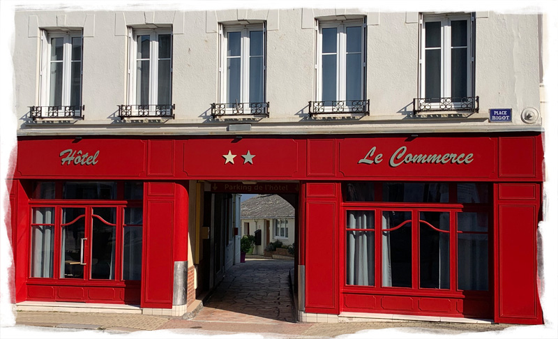 La façade en bois rouge de l'hôtel de Fécamp avec le drapeau français
